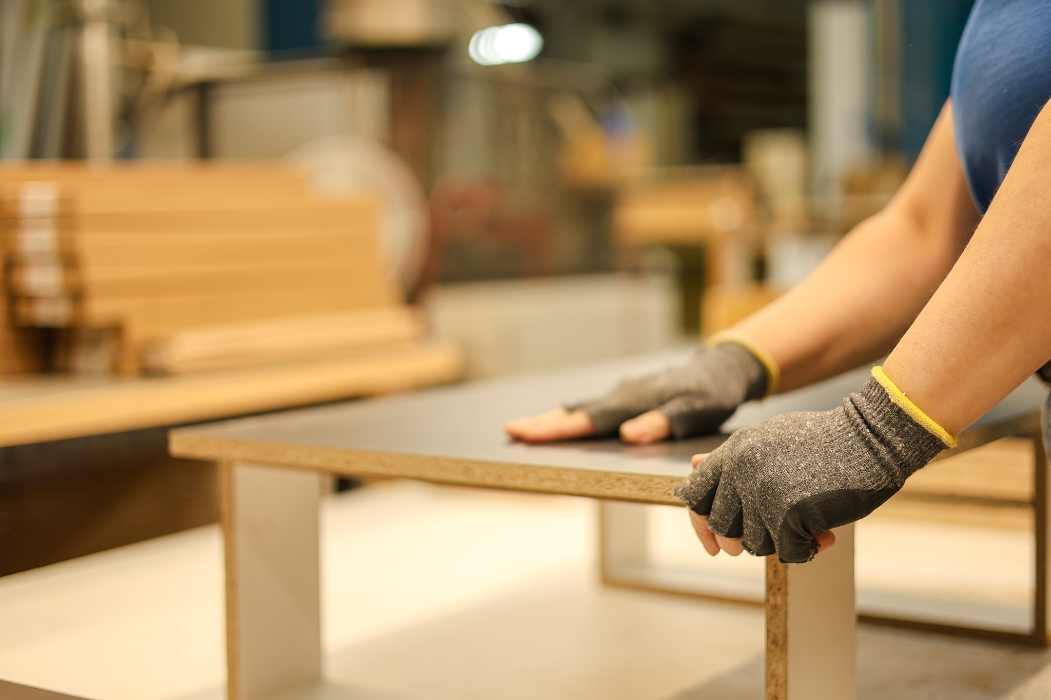 Mains gantées posées sur un panneau en cours de fabrication