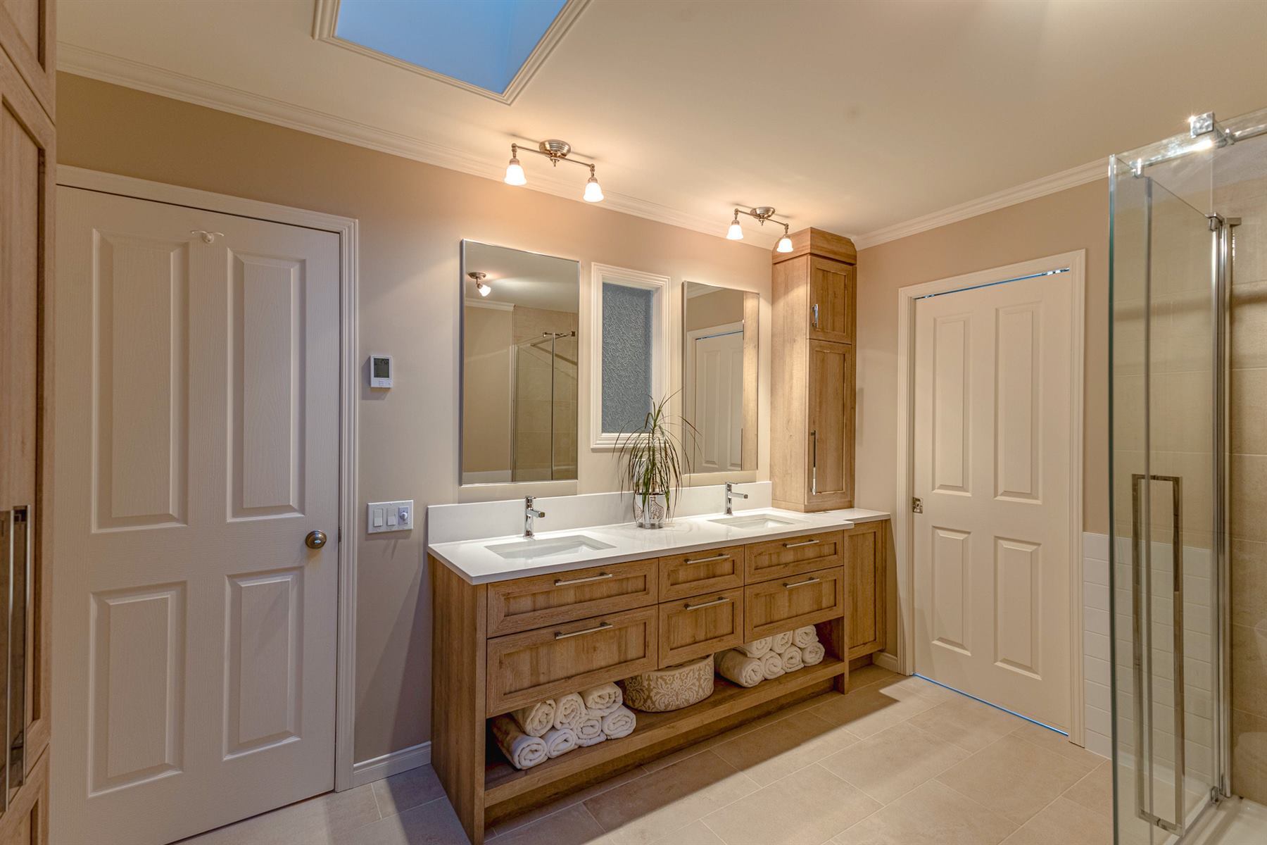 Le Sous-Bois : Vanité double en bois naturel avec rangement ouvert, comptoir de quartz blanc et miroirs jumelés