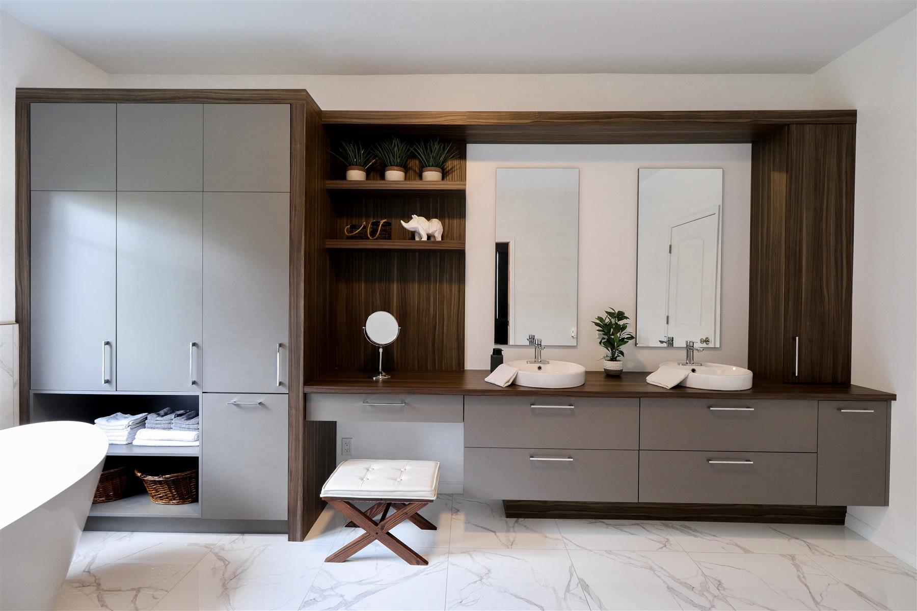 Le Boudoir : Vanité double en bois foncé, plancher de marbre et miroirs muraux, avec coin coiffeuse intégré